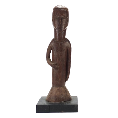 598 - Large African tribal interest carved wood figure of a tribesman raised on an ebonised block base, 57... 