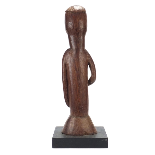 598 - Large African tribal interest carved wood figure of a tribesman raised on an ebonised block base, 57... 