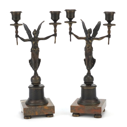 601 - Pair of classical patinated bronze figural two branch candlesticks raised on square marble bases, ea... 