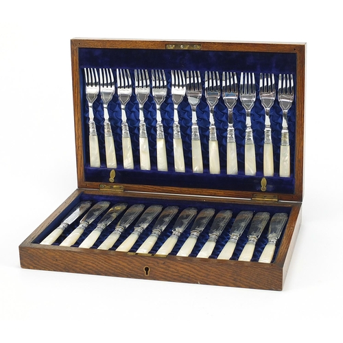 1083 - Oak twelve place canteen of silver plated fish knives and forks with mother of pearl handles, the ca... 