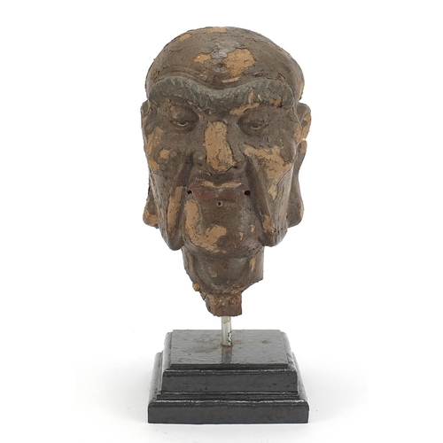 479 - Chinese stucco head raised on a later stepped rectangular plinth base, 28.5cm high