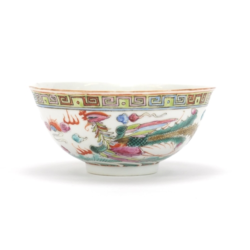 275 - Chinese porcelain bowl hand painted in the famille rose palette with a dragon and phoenix chasing a ... 