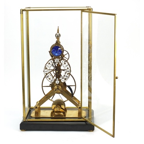 856 - Gothic style brass skeleton clock with moon face dial and glass display case, with key and pendulum,... 