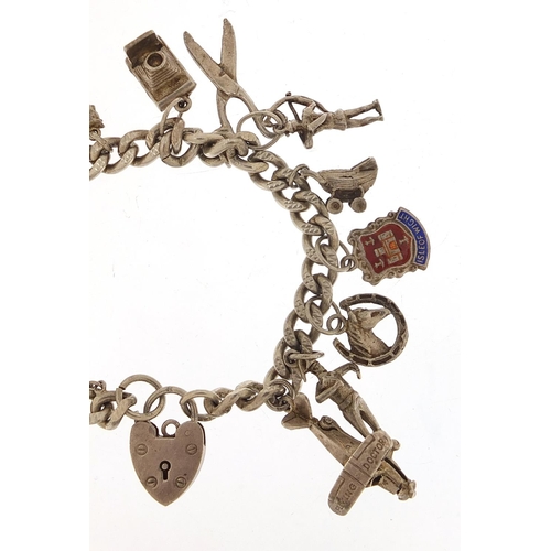 985 - Silver charm bracelet with a selection of mostly silver charms including Flying Doctor aeroplane, ba... 