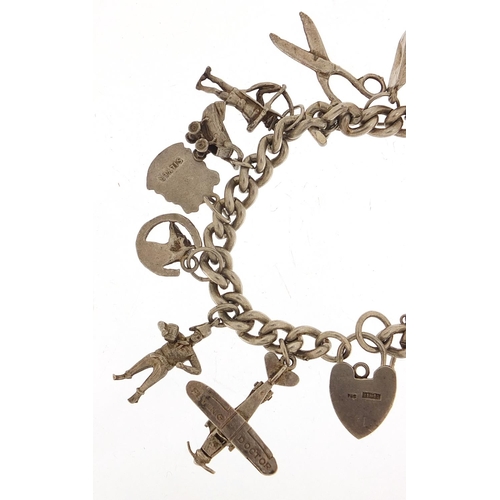 985 - Silver charm bracelet with a selection of mostly silver charms including Flying Doctor aeroplane, ba... 