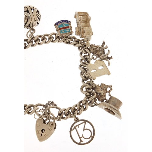 455 - Silver charm bracelet with a selection of mostly silver charms including a top hat, lion, dragon and... 