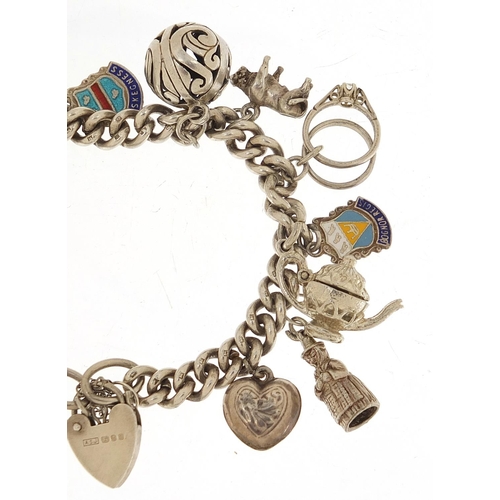 455 - Silver charm bracelet with a selection of mostly silver charms including a top hat, lion, dragon and... 