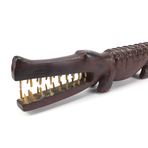 597 - Large African tribal interest carved hardwood alligator with bone teeth, 80cm in length