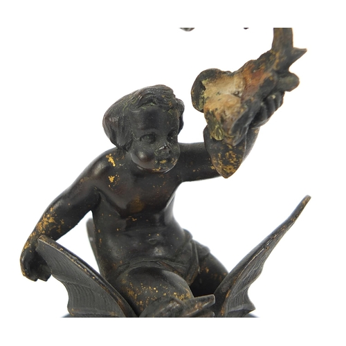 147 - Cold painted bronze figure of Putti on a swan raised on an oval slate base, 11cm high