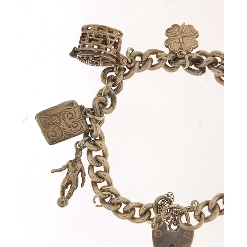 1026 - Silver charm bracelet with a selection of charms including babies' carriage, hedgehog and footballer... 