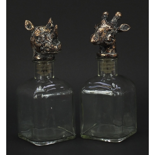 1038 - Pair of glass decanters with rhinoceros and giraffe head stoppers, each 24cm high