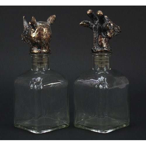 1038 - Pair of glass decanters with rhinoceros and giraffe head stoppers, each 24cm high