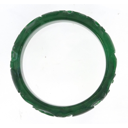 722 - Chinese green jade bangle carved with dragons, 7.5cm in diameter