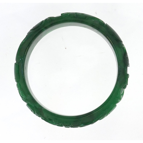 722 - Chinese green jade bangle carved with dragons, 7.5cm in diameter