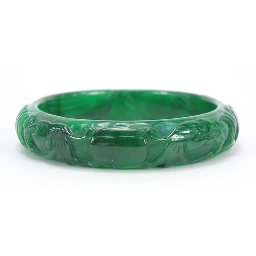 722 - Chinese green jade bangle carved with dragons, 7.5cm in diameter