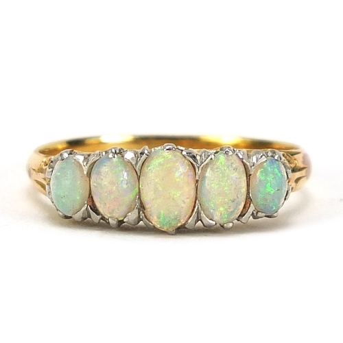 693 - Unmarked gold graduated opal five stone ring, tests as 18ct gold, size O, 2.8g