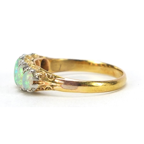 693 - Unmarked gold graduated opal five stone ring, tests as 18ct gold, size O, 2.8g