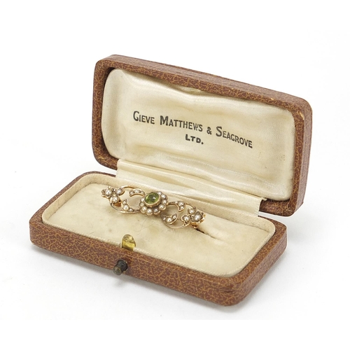 743 - 9ct gold peridot and seed pearl bar brooch, housed in a Gieve Matthews & Seagrove Ltd tooled leather... 