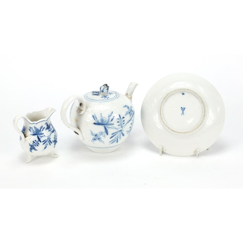 869 - Meissen Blue Onion pattern comprising teapot, three footed cream jug and saucer, the largest 17cm in... 