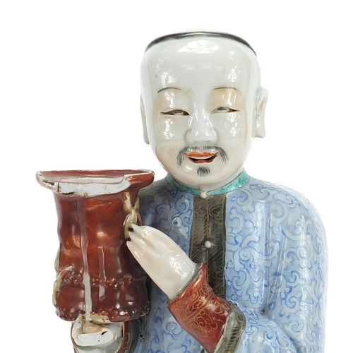 718 - Chinese porcelain figural candlestick of a robed gentleman hand painted in the famille rose palette,... 