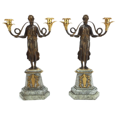 151 - Pair of classical partially gilt bronze two branch candelabras of horn blowers raised on tapering tr... 