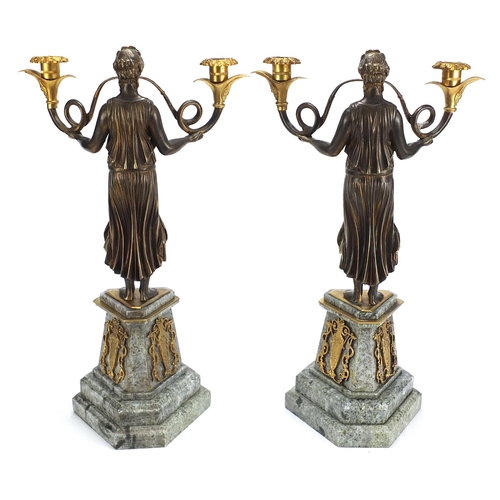 151 - Pair of classical partially gilt bronze two branch candelabras of horn blowers raised on tapering tr... 