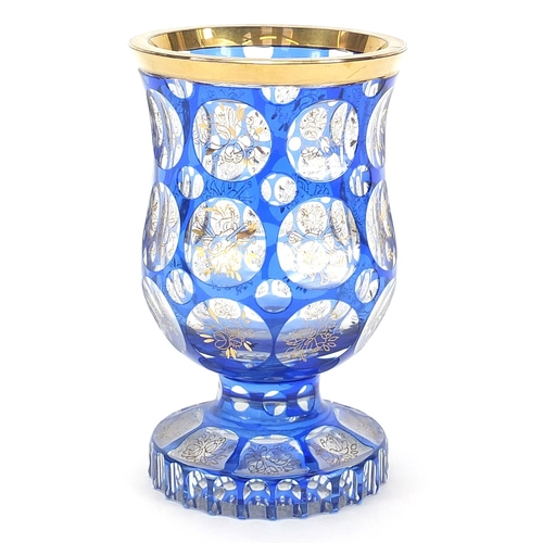 84 - Bohemian blue flashed glass goblet vase gilded with flowers and instruments, 16cm high