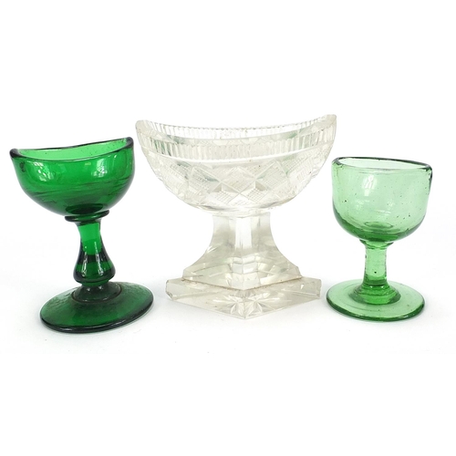 902 - Two Georgian green glass eye baths and a cut glass salt, the largest 8cm high