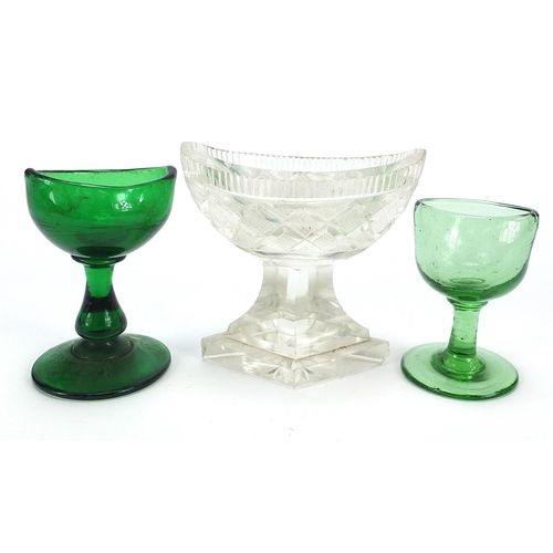 902 - Two Georgian green glass eye baths and a cut glass salt, the largest 8cm high