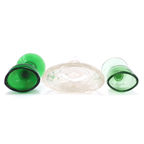 902 - Two Georgian green glass eye baths and a cut glass salt, the largest 8cm high