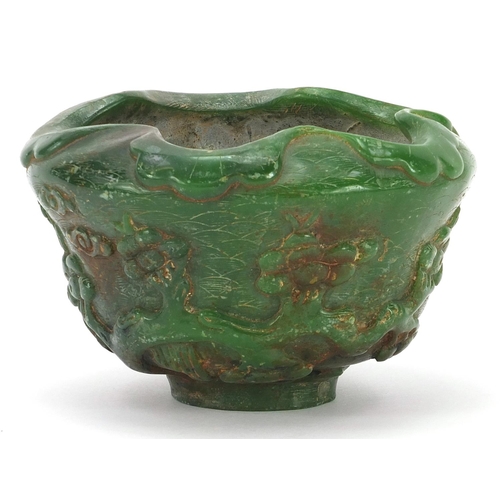 831 - Chinese green jade bowl carved with cranes in a landscape amongst prunus blossom, 13cm in diameter