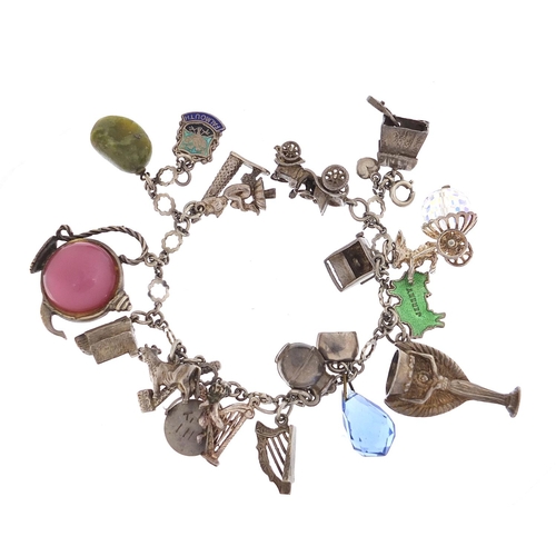 745 - Silver charm bracelet with a large selection of charms including a 1966 World Cup trophy, Putti play... 