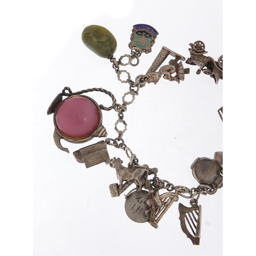 745 - Silver charm bracelet with a large selection of charms including a 1966 World Cup trophy, Putti play... 