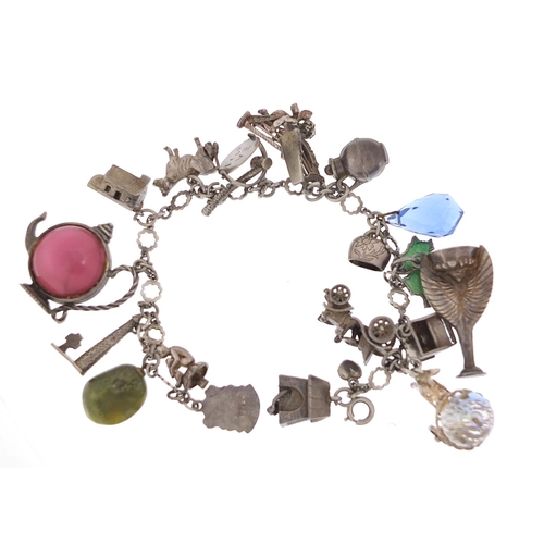 745 - Silver charm bracelet with a large selection of charms including a 1966 World Cup trophy, Putti play... 