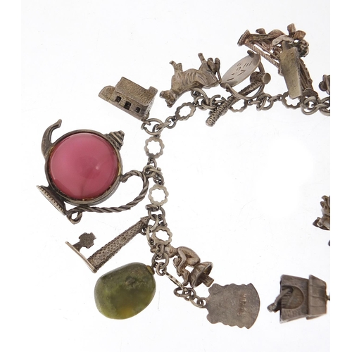 745 - Silver charm bracelet with a large selection of charms including a 1966 World Cup trophy, Putti play... 