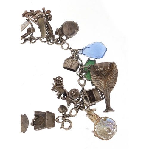 745 - Silver charm bracelet with a large selection of charms including a 1966 World Cup trophy, Putti play... 