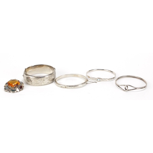 545 - Four silver bangles and a Scottish agate and citrine brooch, total 91.7g