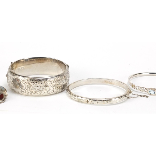 545 - Four silver bangles and a Scottish agate and citrine brooch, total 91.7g