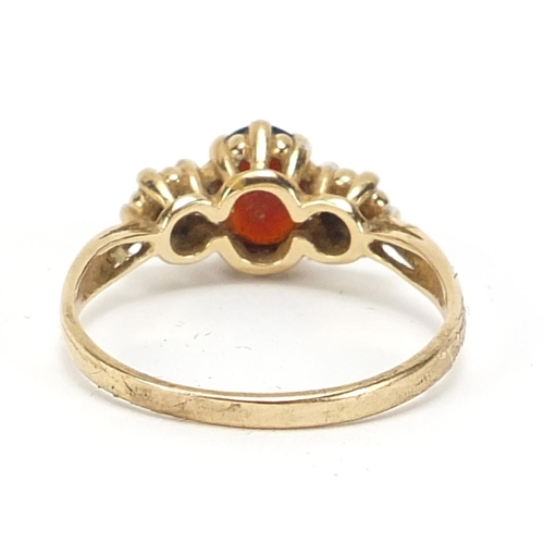 581 - 9ct gold diamond and garnet three stone ring, size U, 2.7g