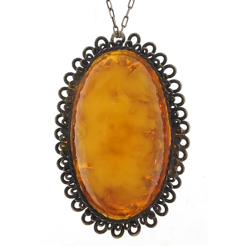 1122 - Large silver mounted amber pendant on a silver chain, the pendant 5cm high, total 15.8g