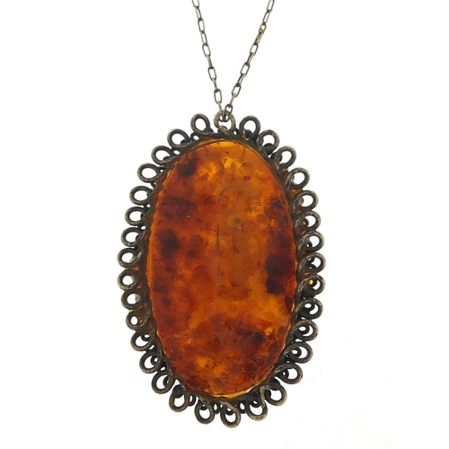 1122 - Large silver mounted amber pendant on a silver chain, the pendant 5cm high, total 15.8g