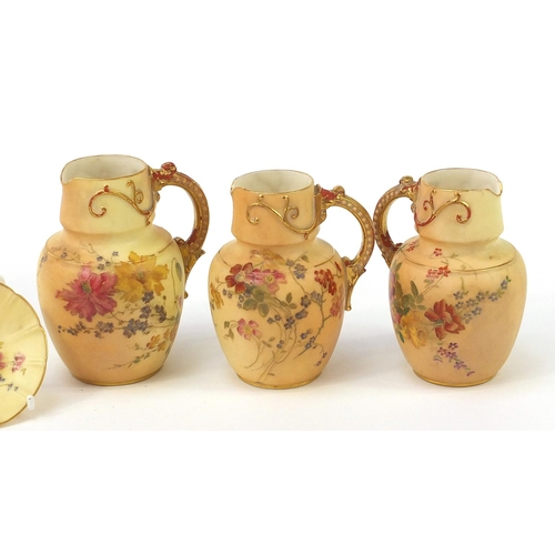 75 - Royal Worcester blush ivory comprising three jugs, pair of dishes and a side plate, each decorated w... 