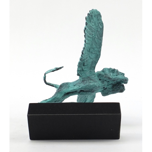 1079 - McArthur Glen Group, Verdigris bronze study of winged lion raised on a rectangular slate base with b... 