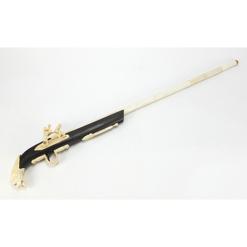 354 - Indian style hardwood and carved bone walking stick in the form of a rifle, 92cm in length