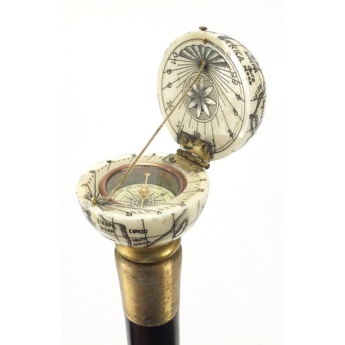 355 - Hardwood walking stick with carved bone globe and compass design pommel, 88cm in length