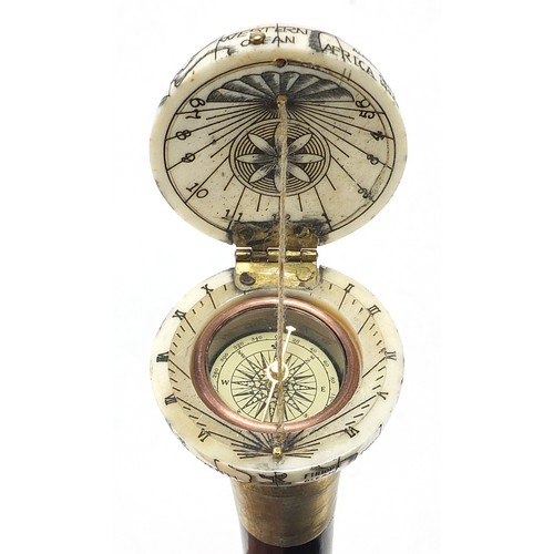 355 - Hardwood walking stick with carved bone globe and compass design pommel, 88cm in length