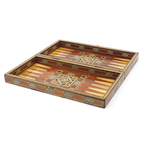 931 - Syrian Moorish design inlaid folding games/chess board with draught pieces, 49cm x 49cm when open