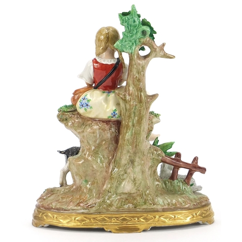 404 - German porcelain figurine of a female playing a flute with a kid and two lambs, 19.5cm high