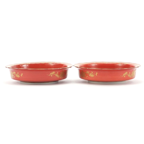 166 - Pair of Japanese iron red ground porcelain dishes hand painted and gilded with flowers, each with ch... 