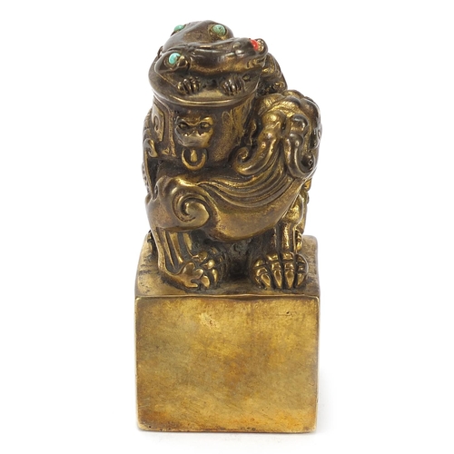 168 - Chinese patinated bronze dog of Foo seal set with turquoise and coral coloured stones, 12cm high